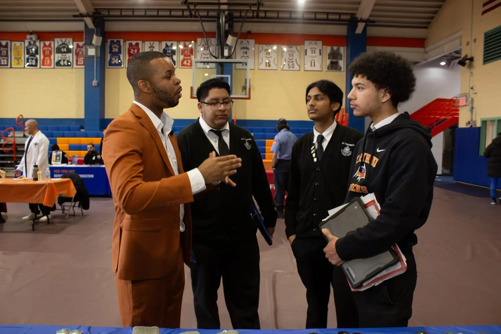 Merrick Lee Jr. talking with a small group of students at the career day