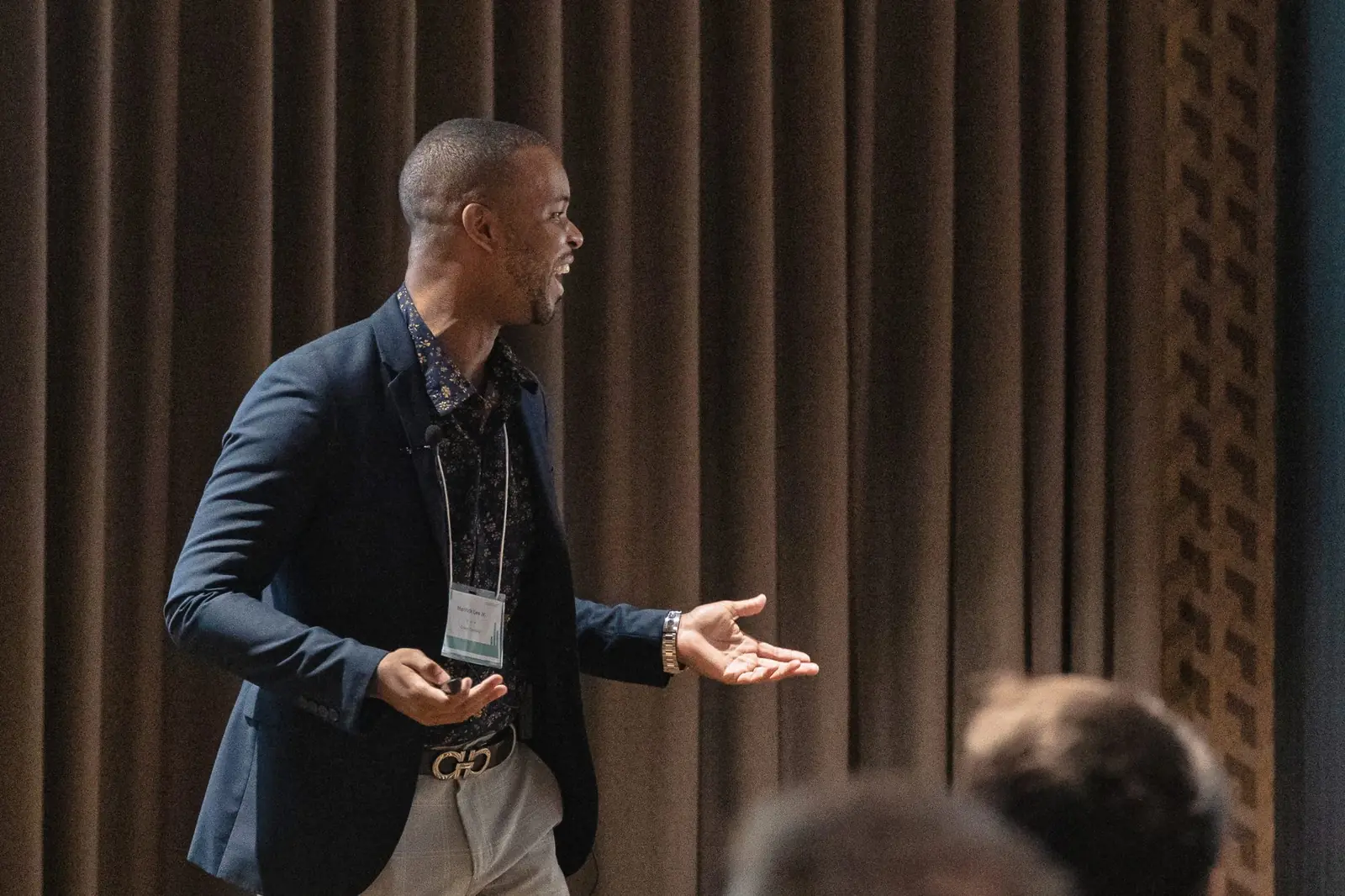 Merrick Lee speaking with arms open to the audience at the Avestor Fund Managers Retreat